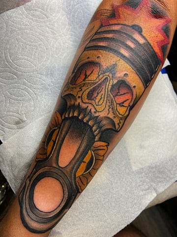 Neo-Traditional Motor Piston and Skull Tattoo in Color Neo-Traditional tattoo of a motor piston and skull in vibrant color, with bold outlines and detailed shading
