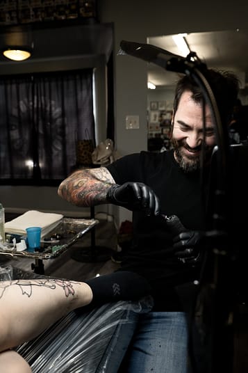 Creating a Custom Japanese Leg Sleeve Tattoo in Sacramento Tattoo artist working on a custom Japanese leg sleeve tattoo in Sacramento studio